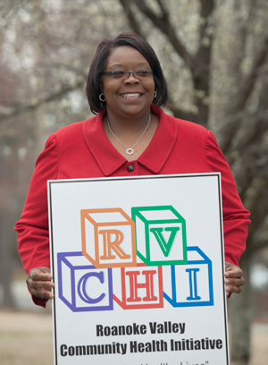 woman holding a Roanoke Valley Community Health Initiative sign