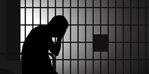 silhouette of a man in a jail cell
