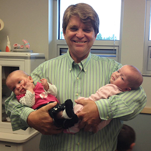 Dr. John Cullen, holding two babies he delivered
