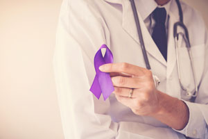 doctor holding a purple ribbon